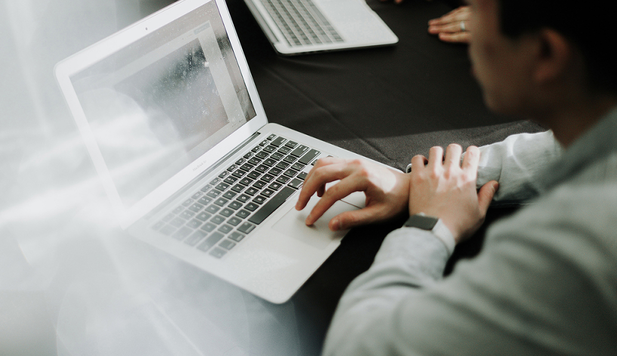 A man sitting in front of a laptop computer