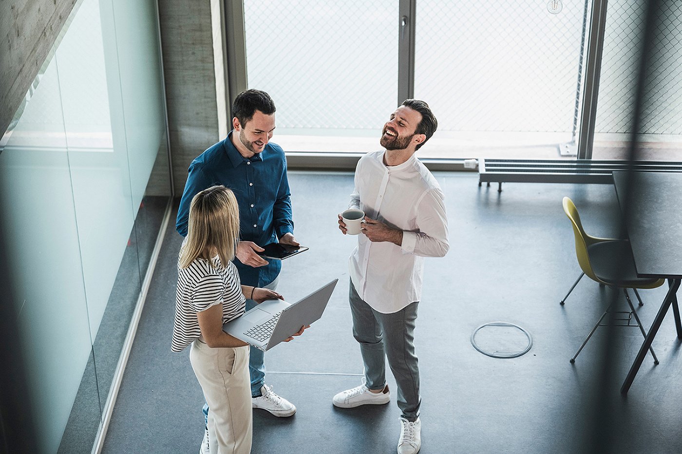 Businessman laughing with colleagues in office_high (1)